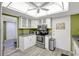 Compact kitchen featuring white cabinets, stainless steel appliances, and gray countertops at 6415 Midnight Pass Rd # 211, Sarasota, FL 34242
