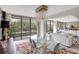 Bright living room featuring modern chandelier, colorful rug, floor to ceiling windows, and balcony access at 6415 Midnight Pass Rd # 211, Sarasota, FL 34242