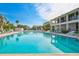 Large community pool with blue water, surrounded by lounge chairs and a multi-story building at 6415 Midnight Pass Rd # 211, Sarasota, FL 34242