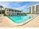Inviting community pool with lounge chairs and umbrellas adjacent to a multi-story building at 6415 Midnight Pass Rd # 211, Sarasota, FL 34242
