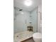Modern glass enclosed shower features stylish blue tile, river rock flooring, and a convenient corner seat at 6415 Midnight Pass Rd # 211, Sarasota, FL 34242