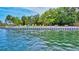 A serene waterfront view with colorful lounge chairs and lush tropical landscaping at 6415 Midnight Pass Rd # 211, Sarasota, FL 34242