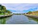 Waterfront view showcasing a wide canal with docks, lush greenery, and a clear sky at 6415 Midnight Pass Rd # 211, Sarasota, FL 34242