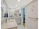 Bright bathroom with double sinks, elegant fixtures, and an adjacent door to a storage area at 6415 Midnight Pass Rd # 910, Sarasota, FL 34242