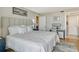 Bright bedroom with a soft headboard, white bedding, and an adjacent desk space at 6415 Midnight Pass Rd # 910, Sarasota, FL 34242