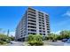Low angle view of the condo building displaying balconies and mature landscaping at 6415 Midnight Pass Rd # 910, Sarasota, FL 34242