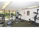 Community exercise room with exercise equipment, sliding glass doors and neutral carpet at 6415 Midnight Pass Rd # 910, Sarasota, FL 34242
