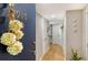 Bright hallway with a flower decoration on the door to unit 910 and hardwood floors at 6415 Midnight Pass Rd # 910, Sarasota, FL 34242