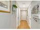 Clean hallway with neutral paint, decorative art, and wooden flooring leading to rooms at 6415 Midnight Pass Rd # 910, Sarasota, FL 34242