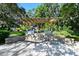Outdoor grill area with a pergola and multiple grills, in a shaded setting at 6415 Midnight Pass Rd # 910, Sarasota, FL 34242