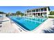 Community pool with lounge seating area, and manicured landscaping at 6415 Midnight Pass Rd # 910, Sarasota, FL 34242