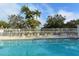 Community pool with clear blue water and lounge chairs for relaxation, set against a backdrop of palm trees at 7214 Cedar Hollow Cir, Bradenton, FL 34203