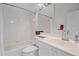 A clean, all-white bathroom with ample light features a shower/tub, toilet and long vanity with storage at 7312 Eleanor Cir, Sarasota, FL 34243