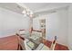 Well-lit dining area with a glass table, six chairs, and views of the kitchen and other living spaces at 7312 Eleanor Cir, Sarasota, FL 34243