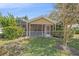 Rear exterior view of home featuring a screened-in lanai and lush landscaping at 7312 Eleanor Cir, Sarasota, FL 34243
