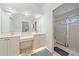 A well-lit bathroom includes a double vanity, ample counter space, and a glass-enclosed shower at 7312 Eleanor Cir, Sarasota, FL 34243