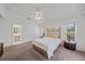 Bright main bedroom featuring a decorative headboard, neutral carpet and access to the main bathroom at 7312 Eleanor Cir, Sarasota, FL 34243