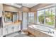 This primary bathroom has a large glass shower, bathtub, and a large window at 7601 226 E St, Bradenton, FL 34211