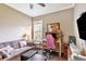 Small bedroom with desk and pink gamer chair next to window. Has a brown couch for relaxing at 7601 226 E St, Bradenton, FL 34211