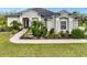 Charming single-story home with a well-manicured lawn, mature landscaping, and a lovely front garden with a small fountain at 7601 226 E St, Bradenton, FL 34211