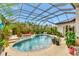 The screened-in pool and hot tub are surrounded by plants at 7601 226 E St, Bradenton, FL 34211