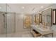 Modern bathroom featuring double sinks, sleek lighting, and a glass shower at 775 Longboat Club Rd # 604, Longboat Key, FL 34228