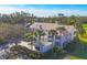 Aerial view of the condo building with landscaping including palm trees and tiled roof at 801 Montrose Dr # 202, Venice, FL 34293