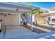 Exterior of condos featuring covered parking, landscaped walkway, and stair access to upper units at 801 Montrose Dr # 202, Venice, FL 34293