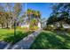Well-maintained property with lush green lawn, mature trees, and a welcoming walkway leading to the entrance at 801 Montrose Dr # 202, Venice, FL 34293