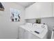 Convenient laundry room with modern washer and dryer, plus storage cabinets for efficient organization at 801 Montrose Dr # 202, Venice, FL 34293
