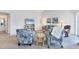 Cozy living room with plush seating, beach-themed art, ceiling fan, and natural light at 801 Montrose Dr # 202, Venice, FL 34293
