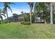 Lush backyard featuring a swing set, screened-in lanai, and manicured lawn at 820 Placid Lake Dr, Osprey, FL 34229
