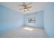 This blue bedroom features a ceiling fan and a window with a lake view at 820 Placid Lake Dr, Osprey, FL 34229