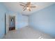 Blue bedroom with a ceiling fan, carpet floors, and a closet for lots of storage at 820 Placid Lake Dr, Osprey, FL 34229