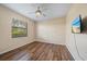 Clean bedroom with wood floors, a ceiling fan, natural light, and a mounted TV at 820 Placid Lake Dr, Osprey, FL 34229