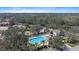 Aerial view of the community pool area, surrounded by trees and featuring a nearby parking lot at 820 Placid Lake Dr, Osprey, FL 34229