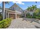 Stunning two-story home featuring a three-car garage, beautiful landscaping, and a brick paved driveway at 820 Placid Lake Dr, Osprey, FL 34229