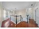 Upstairs hallway featuring hardwood floors, black and white banister, and natural light at 820 Placid Lake Dr, Osprey, FL 34229