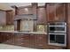 Kitchen features dark cabinets, granite countertops, stainless steel appliances, and decorative backsplash at 820 Placid Lake Dr, Osprey, FL 34229