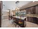 Open kitchen features large island, dark wood cabinets, stainless steel appliances, and tiled floor at 820 Placid Lake Dr, Osprey, FL 34229