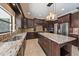 Spacious kitchen features dark cabinets, stainless steel appliances, granite countertops, and center island at 820 Placid Lake Dr, Osprey, FL 34229