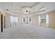 Spacious main bedroom featuring large windows, a ceiling fan, and tray ceiling at 820 Placid Lake Dr, Osprey, FL 34229