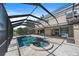 Rear exterior featuring screened-in pool and patio overlooking the tranquil lake at 820 Placid Lake Dr, Osprey, FL 34229