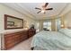 Bright bedroom featuring tray ceilings, ceiling fan and dresser at 9039 Willowbrook Cir, Bradenton, FL 34212