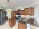 Spacious kitchen with dark wood cabinetry, granite countertops, and stainless steel appliances at 9039 Willowbrook Cir, Bradenton, FL 34212