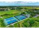 Aerial shot of the well-maintained community tennis courts surrounded by landscaping, offering residents an active lifestyle at 9039 Willowbrook Cir, Bradenton, FL 34212