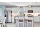 A modern kitchen featuring white cabinetry, stainless steel appliances, and stylish pendant lighting over a center island at 9091 Royal River Cir, Parrish, FL 34219