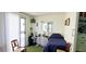 Bedroom with green carpet, small desk, shelving, and a door leading to an outdoor patio at 10315 Cortez W Rd # 28-1, Bradenton, FL 34210