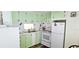 Efficient kitchen with light green cabinetry, white appliances, double sink and great natural light at 10315 Cortez W Rd # 28-1, Bradenton, FL 34210