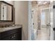 Bathroom vanity with granite counters, a large mirror, and tile flooring leading to the shower at 10406 Eastwood Dr, Bradenton, FL 34211